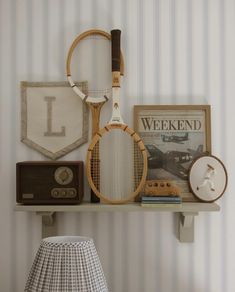 a shelf with some tennis rackets and other items on it next to a lamp