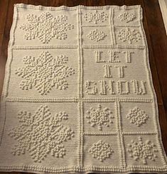 a white crocheted blanket on top of a wooden floor