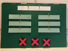 a green bulletin board with red and white paper cut out of it's sides