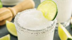 two margaritas are garnished with lime and sugar