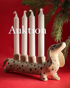 a dalmatian dog figurine sitting in front of candles with the word aukttion written above it