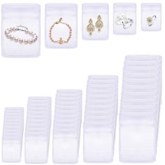 a bunch of jewelry sitting on top of a white table next to some plastic containers