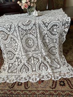 a table topped with a white lace covered table cloth