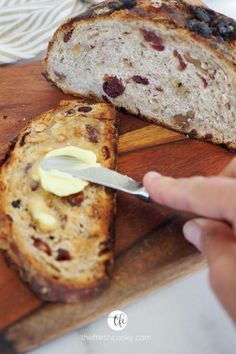 Hand buttering a toasted slice of Cranberry Walnut Bread with loaf sitting behind on a cutting board. Overnight Bread, Bread No Knead, Cranberry Nut Bread, Walnut Bread Recipe, Cranberry Walnut Bread, Walnut Bread