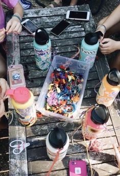 several people sitting around a table with drinks and candy in containers on top of it