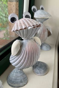 three seashells are sitting on the window sill