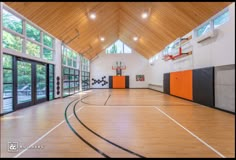 an indoor basketball court with hardwood floors and windows