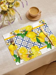 a place mat with lemons on it next to a coffee cup and saucer