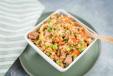 a bowl filled with rice and meat on top of a green plate