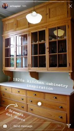 a kitchen cabinet with glass doors and drawers