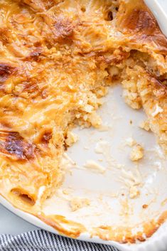 a casserole dish with cheese and meat in it on a white plate, ready to be eaten