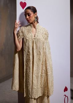 A dazzling showcase of hand embroideries and intricate details, our jane cape set is a masterful creation, featuring an opulently embellished voluminous cape, sumptuously adorned pants, and a charming blouse. Traditional Evening Cape Sets, Elegant Cape Sets For Reception, Designer Sets With Pearl Embroidery And Cape Sleeves, Elegant Designer Cape Set, Traditional Dresses With Pearl Embroidery And Cape Sleeves, Elegant Cape Dupatta For Reception, Embroidered Sets With Cape Sleeves For Evening, Elegant Cape-shaped Dupatta For Reception, Elegant Cape-style Dupatta For Reception