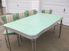 a green table with six chairs sitting next to each other in front of a garage door