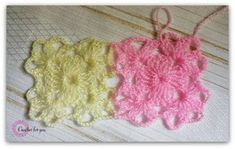 two crocheted doily are sitting on a white wooden surface, one is pink and the other is yellow