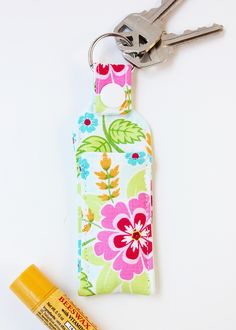 a keychain with a flower print and a bottle of glue next to it