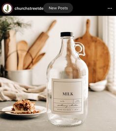 a bottle of milk sitting on top of a table next to a plate with food