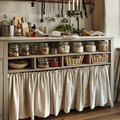 a kitchen with lots of utensils hanging on the wall and drawers below it