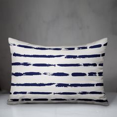 a blue and white striped pillow sitting on top of a table next to a wall