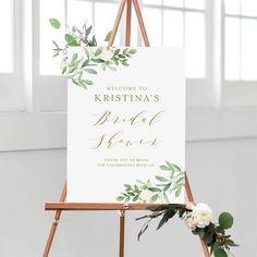 a welcome sign on an easel with greenery