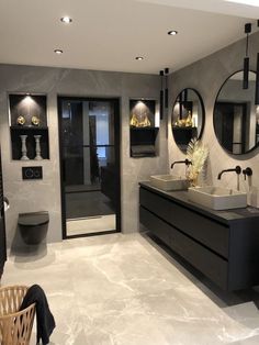 a modern bathroom with two sinks and mirrors on the wall, along with black cabinets