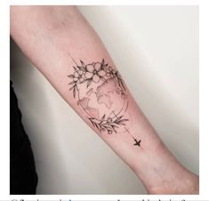 a woman's arm with flowers and a world map tattoo on the left forearm