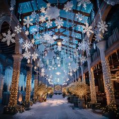 the inside of a building decorated with lights and snowflakes hanging from the ceiling