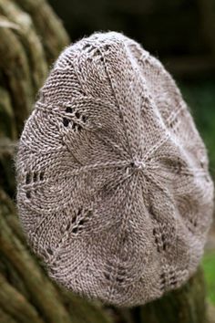 a knitted hat sitting on top of a tree