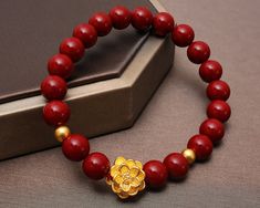 Visist our shop to get more Jewelry ideas and choices! https://www.etsy.com/shop/FamilyJewelryCo Design Name: Strengthful Lotus Design Meaning: The gold lotus and 2 balls rebirth in the surrounded red cinnabar beads means ennergy and strength, purity and rebirth, good luck. Material Lotus & Balls: 24K 999 Gold Red Beads: Red Cinnabar Rope: Elastic Nylon Rope Default Size:  Gold Lotus: 13*13*8.5 MM; Gold Balls: 4 MM (Diameter), about 1-1.1 g Red Beads: 8.5 MM (Diameter) (The Gold Size is fixed, t Gemstone Beaded Bracelets For Festivals And Gifts, Traditional Gold Beaded Bracelets With Gemstone Beads, Traditional Red Bracelets With 8mm Beads, Red Round Beaded Bracelets For Festivals, Traditional Red Gemstone Beads Bracelet, Handmade Jewelry With Round Beads For Gifts, Red Beads For Festivals Gift, Traditional Yellow Gold Beaded Bracelets As Gift, Red Beads For Festival Gifts