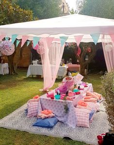 a pink and white tent set up in the yard for a tea party with bunting