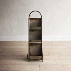 a tall metal shelf sitting on top of a hard wood floor next to a white wall