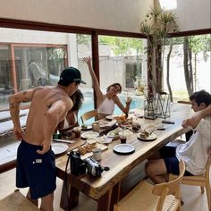 a group of people sitting around a table with food and drinks in front of them