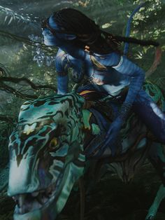 a woman riding on the back of a blue horse through a forest filled with trees