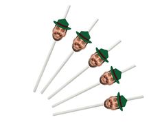 four green hats on top of three white sticks with one man's face in the middle