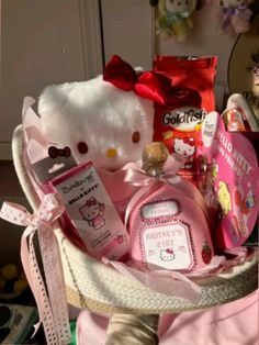 a teddy bear sitting in a basket filled with baby items