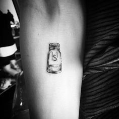 a jar with the letter s in it is sitting on someone's left arm