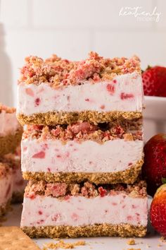 strawberry cheesecake bars stacked on top of each other with strawberries in the background