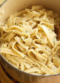 a pot full of pasta with a wooden spoon in it