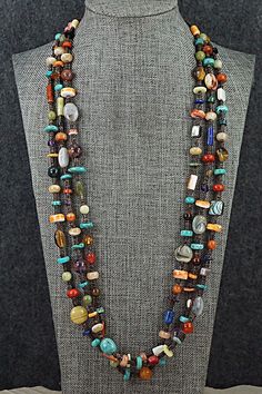 This three-strand turquoise, coral, lapis, amber, spiny oyster, mother of pearl, abalone, jasper, onyx, amethyst and sterling silver necklace was made by Navajo artisan Helen Tsosie.Necklace: 29" with an additional 2" extender chainWidth: 1/8" to 1/2"Free shipping on all orders! We ship with USPS and always include tracking. All orders ship within a day of payment.Returns are accepted up to 30 days after you receive your order. Just send us a message. Our shop offers cash back or store credit. The item must be returned in new condition. Southwestern Multi-strand Necklace With Gemstone Beads, Southwestern Multi-strand Gemstone Bead Necklaces, Artisan Multi-strand Jewelry With Natural Stones, Unique Multicolor Double Strand Jewelry, Southwestern Multicolor Gemstone Beaded Necklaces, Handmade Multicolor Multi-strand Turquoise Necklace, Multicolor Gemstone Southwestern Necklace, Southwestern Multicolor Gemstone Necklace, Southwestern Style Multicolor Gemstone Necklace