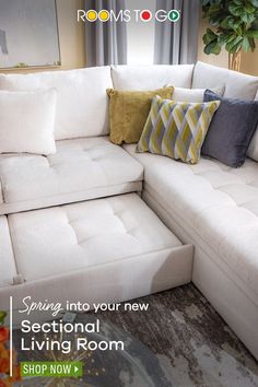 a white sectional couch with pillows on it