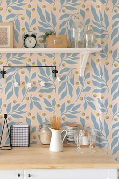 a kitchen with blue and yellow wallpaper on the walls, white cabinets and shelves