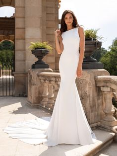 a woman in a white wedding dress posing for the camera