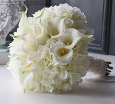 a bouquet of white flowers sitting on top of a table