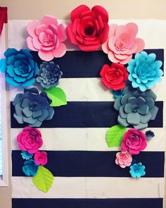 paper flowers are arranged on the side of a striped wall