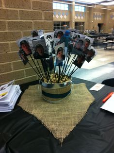 an arrangement of photos in a bowl on top of a table with black linens