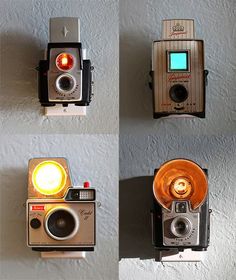 four different types of old cameras mounted to the side of a wall with lights on them