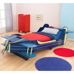 a child's bedroom with an airplane bed and rugs on the wooden floor