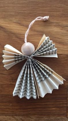 an ornament made out of old book pages and string on a wooden table