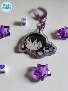 a keychain with an anime character on it's face surrounded by purple and white candies