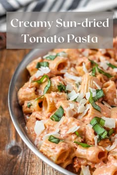 creamy sun - dried tomato pasta in a bowl with parmesan cheese and basil