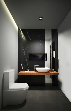 a modern bathroom with black and white walls, wood countertop, toilet and sink